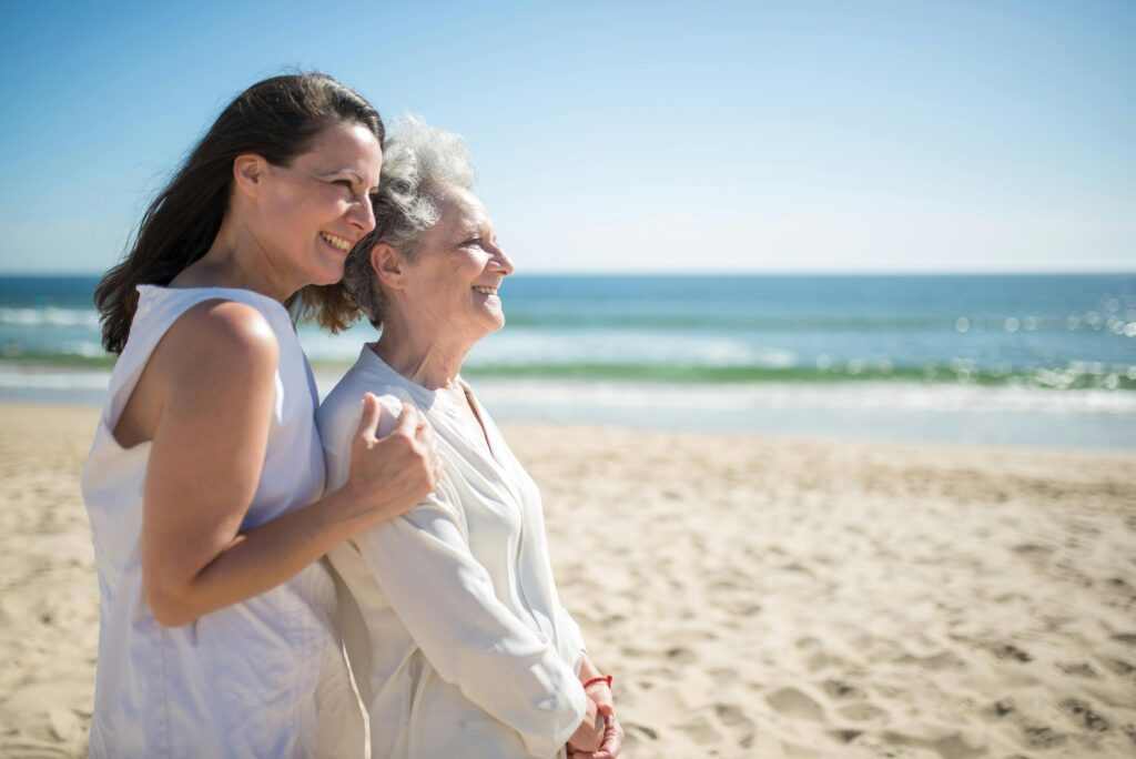 A joyful moment shared by a mother and daughter on a sunny beach in Portugal.